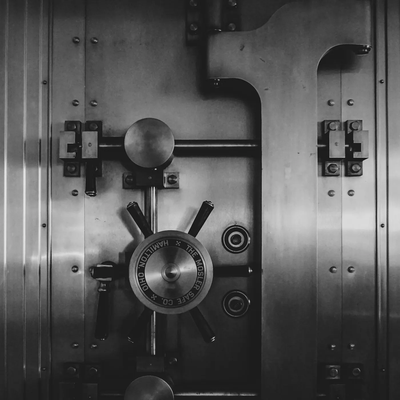 Vintage steel bank vault door, engraved Hamilton, symbolising capital preservation